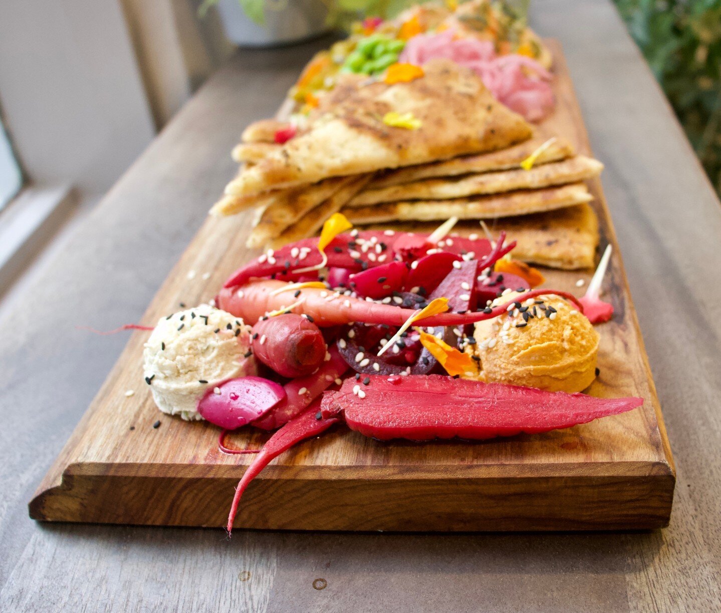 The one and only Plant Food Picnic!⁠
⁠
One of our favorite menu items, this delicious platter includes a rotating selection of hummus, cashew cheeses, and pickled/fermented veggies. Served with toasted gluten free cauliflower pita points.⁠
⁠
It's per