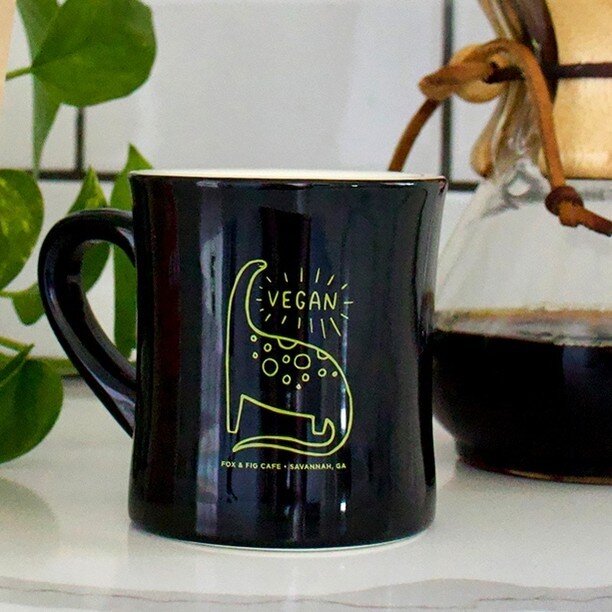Everyone&rsquo;s favorite veggie-saurus, now available on a mug!⁠
⁠
Available in the cafe and online:⁠
www.ShopTheFoxes.com/drinkware⁠
⁠
⁠
⁠
⁠
#foxandfig #plantbased #cafe #vegan #vegandino #veggiesaurus #vegancafe #specialtycoffee #coffee #coffeesho